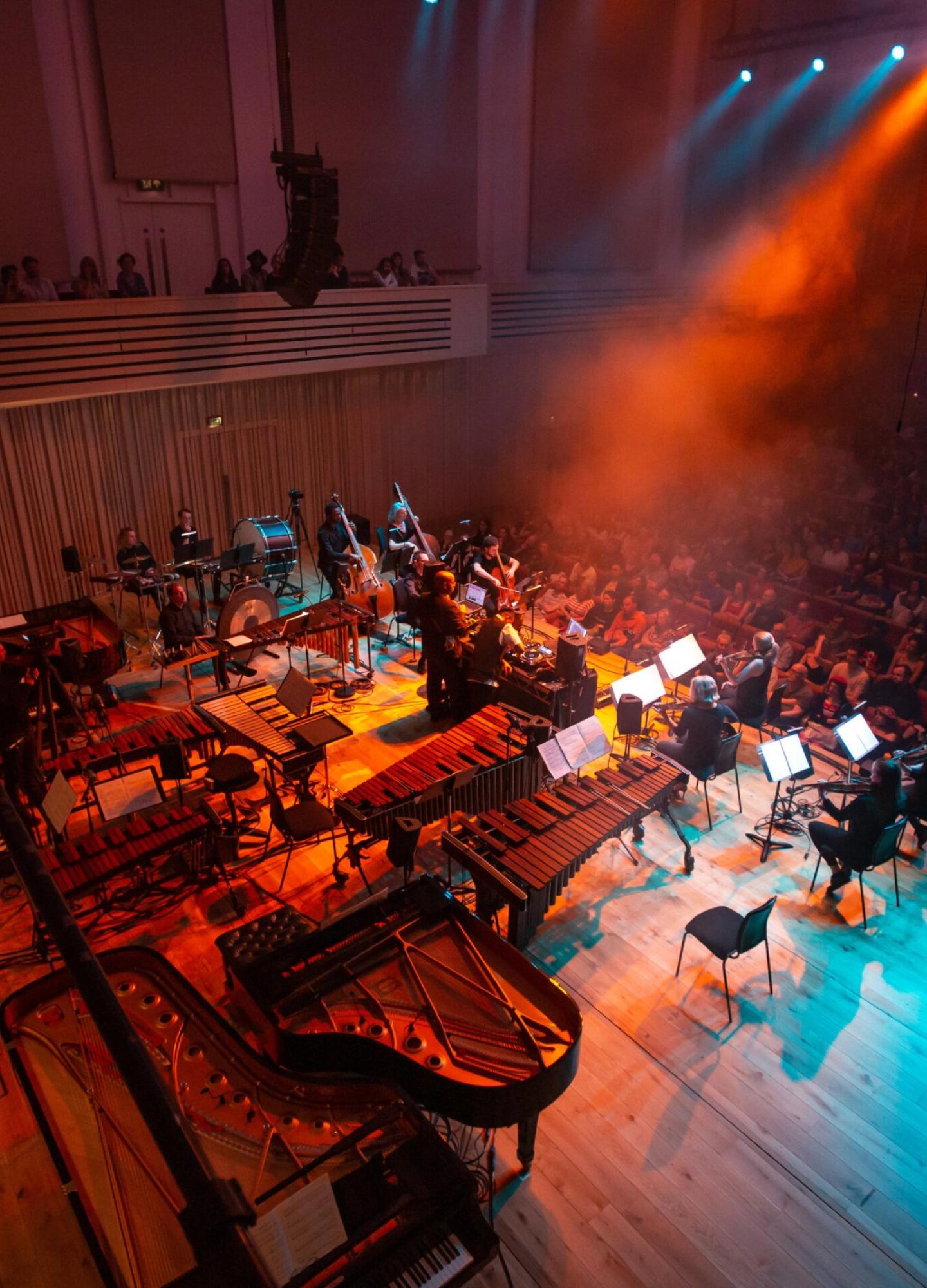 An orchestra on stage performing to an audience